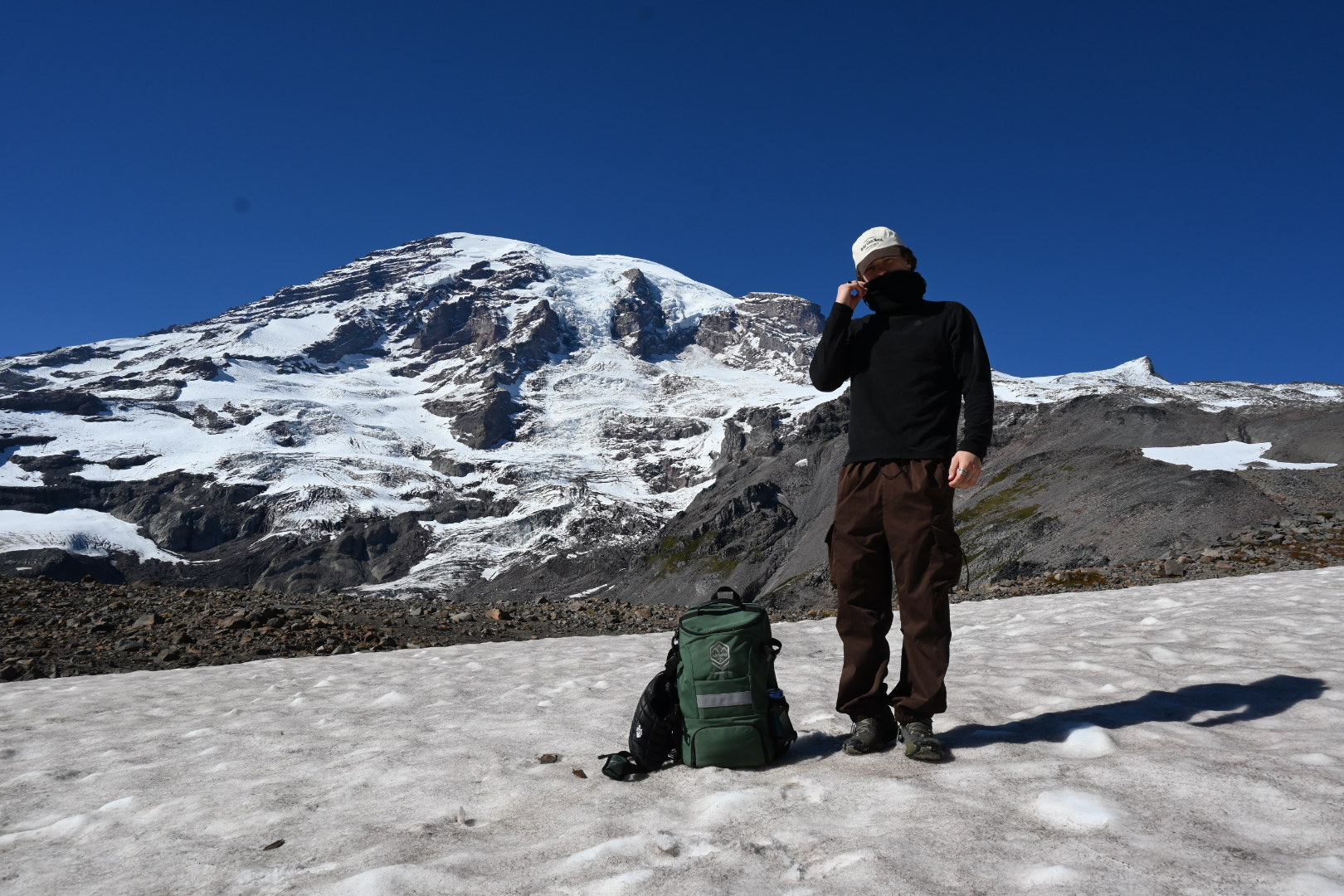 Athlete standing with the MON Supply prototype on snow beneath a mountain